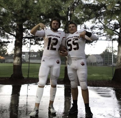 
The team faced a rain delay during their second game of the week and the team took advantage. Junior Ryder Smith and senior Nate Schmidt pose before the game against Poudre High School on Friday, Sept. 2 during the games rain delay. The team lost the game with a score of 14-10 Poudre. “The game was fun and the rain delay did push us a little sideways causing us to lose,” Smith said.