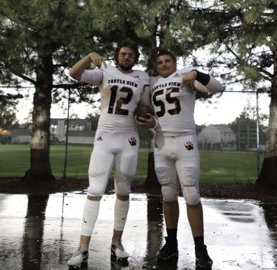 
The team faced a rain delay during their second game of the week and the team took advantage. Junior Ryder Smith and senior Nate Schmidt pose before the game against Poudre High School on Friday, Sept. 2 during the game's rain delay. The team lost the game with a score of 14-10 Poudre. “The game was fun and the rain delay did push us a little sideways causing us to lose,” Smith said.